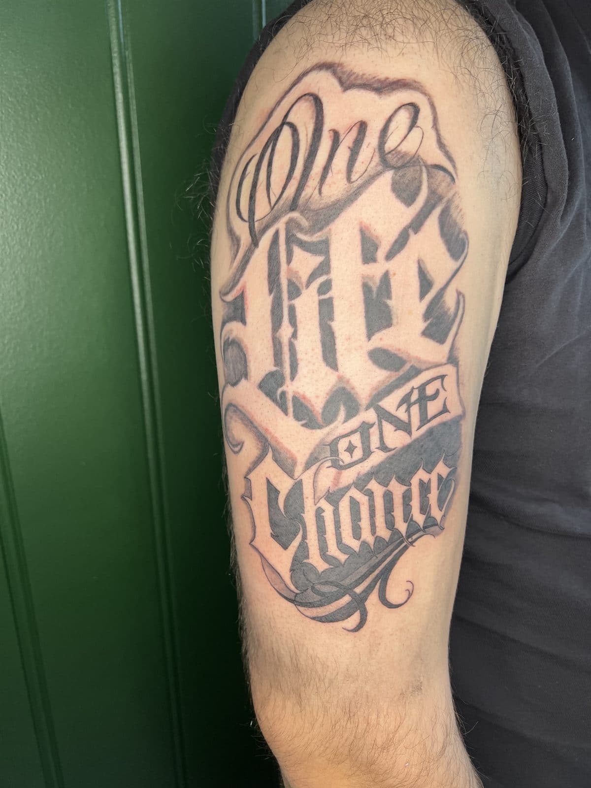 Chicano-lettering på overarm
