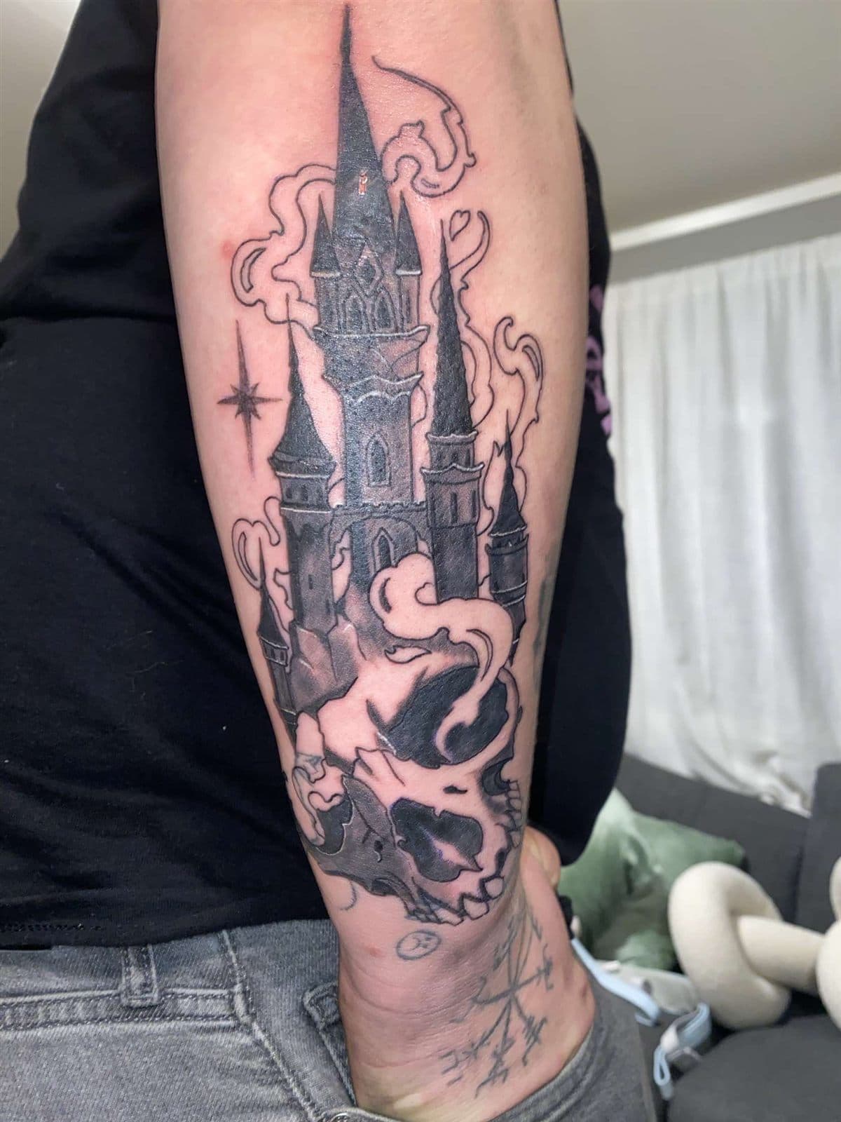 Slott og hovudskalle i blackwork på underarm